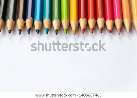 Set of colored pencils in rainbow colors wait for their first picture with a pupil, student or drawer