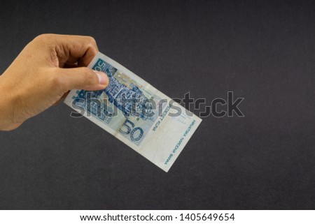 Hand holding Croatian KUNA or STO KUNA bank notes on black background. Financial concept and selective focus