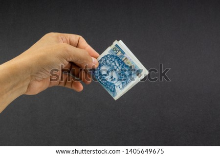 Hand holding Croatian KUNA or STO KUNA bank notes on black background. Financial concept and selective focus