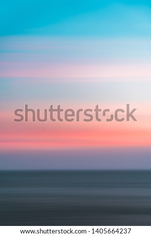 Abstract long exposure photo of a colorful sunset over the Atlantic Ocean near Lisbon, Portugal.