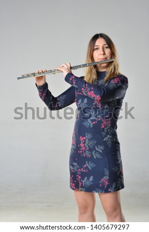 portrait of musician girl in dress with side flute in the white isolated background studio