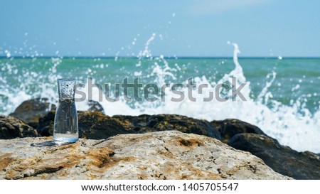 Glass bulb. Sea shore. Waves hit the stones.