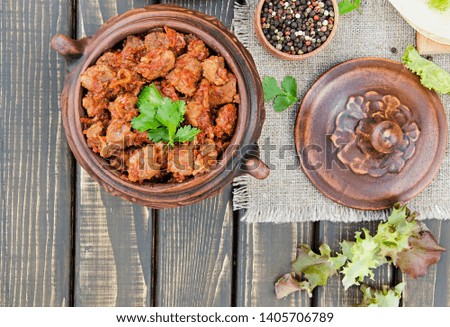 Stew with tomatoes and onions on a dark wooden table.  Top view. Flat lay. Banner