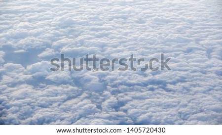 The beautiful cloudscape with clear blue sky. Panorama above white clouds as seen through window of an aircraft. A view from airplane window