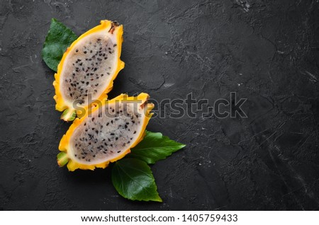 Yellow Pytahya on a black background. Fruit Dragon. Tropical Fruits. Top view. Free space for text.