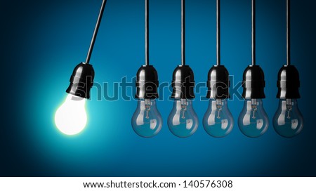 Perpetual motion with light bulbs. Idea concept on blue background. Royalty-Free Stock Photo #140576308
