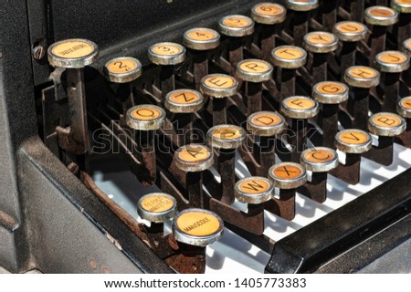 row of yellowed keys of an old typewriter, dating back to the 50s