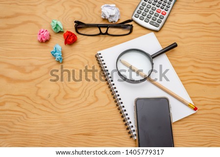 top view book , calculator, glasses on wooden table.