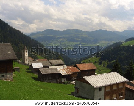 Switzerland green landscape looking over a european village on a mountain hill