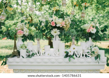 The phrase "Mr & Mrs" in a wedding decor on a white fireplace surrounded by vases of flowers