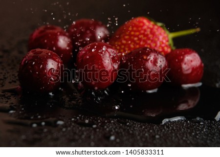 Sweet cherries with strawberries in drops of water