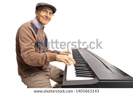 Cheerful senior man playing a digital keyboard piano isolated on white background