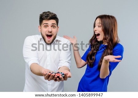 Attractive couple won a lot in online casino with poker chips isolated over grey background