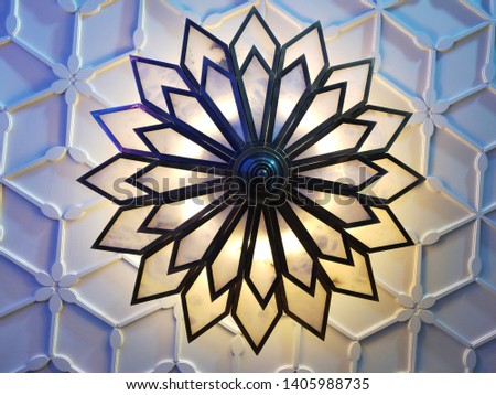 Chandelier is the name of the decorative lamp that hangs on the ceiling.  Which is generally found in this type of lamp  In the hall of the luxurious place