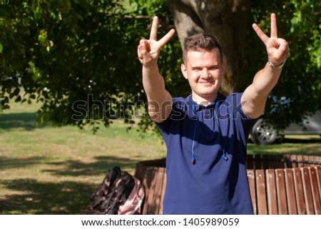 Sport man showing a sign of silence gesture in a park Portrait