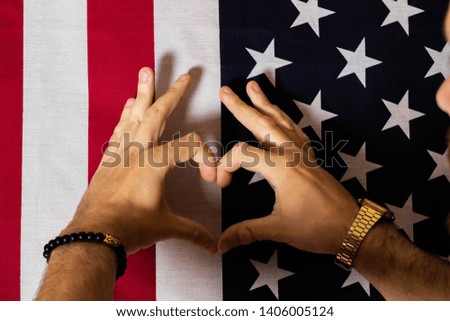 America flag background.Hand making heart sign