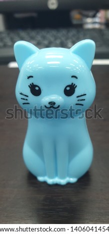 The cat doll has a blue color, the doll is made of plastic.