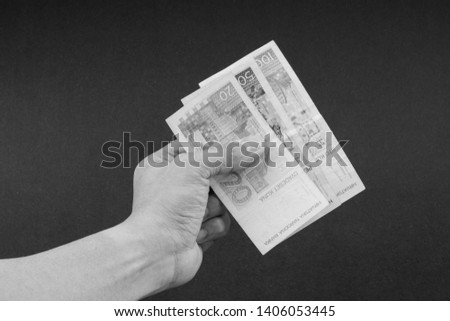 Hand holding Croatian KUNA or STO KUNA bank notes on Black and White. Financial concept and selective focus