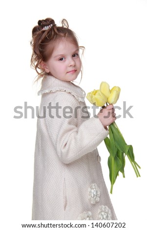 Stylish little girl wearing fashion coat and holding lovely yellow tulips on Holiday theme/Smiley beautiful girl with nice hairstyle