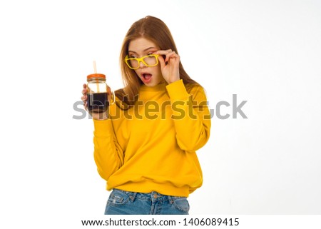 surprised woman in glasses with a drink on an isolated background                               