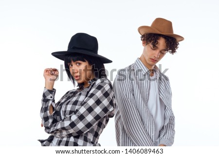  young couple in hats on a light background                              