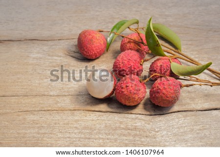 Delicious a group red ripe Lychees Fruit (Litchi chinensis in the soapberry family) on wood texture background.