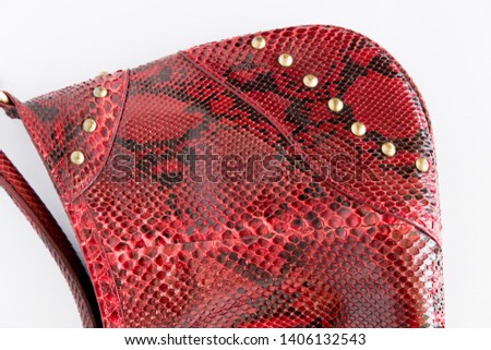 Red leather handbag made of Python skin on a white background. Fashion women's accessories. The view from the top. Python skin. Red clutch. Leather bag.