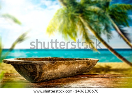 Wooden table and wooden plate of free space for your decoration. Summer landscape of beach with big palms. Summer sunny day and ocean. 