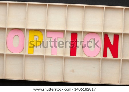 Word OPTION made of colorful alphabet letters on wooden surface.