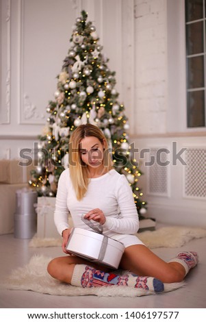 young woman in a dress near the Christmas tree, a girl in the New Year decorations