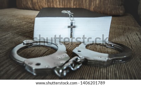 silver cross on bible with handcuffs, concept of Jesus christ the savior liberate people from sin.