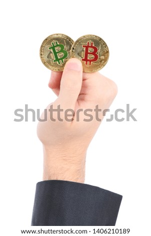 Man's hand holding golden Bitcoin on brown textured cork background. High resolution photo. Full depth of field.