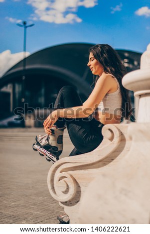 Handsome girl is roller skating on a sunny day in down town, toned photo