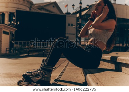 Urban girl rollerblading in street city. active lifestyle, toned image, low key on hot day