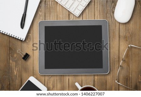 Office workplace with text space, White wooden table with office supplies tablet, desktop computer and book, top view, over light