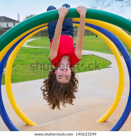 children kid girl upside down on a park playground ring game Royalty-Free Stock Photo #140623249