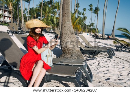  woman with a hat sitting on a beach                              