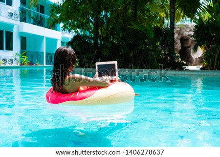 girl in the inflatable circle in the pool with a laptop, the concept of freelancing and recreation