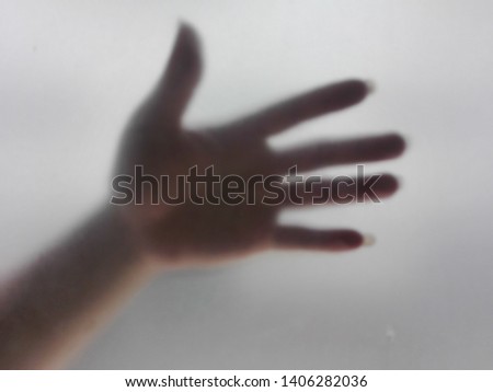  blurry image of the shadowy image of the hand behind the mirror