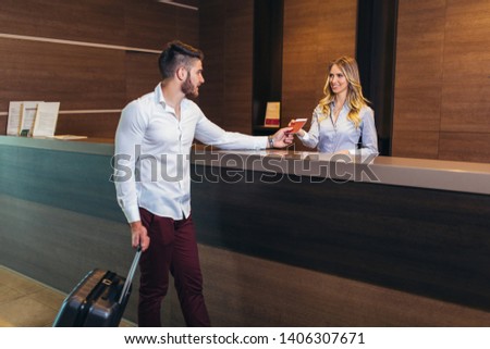 Nice friendly woman talking to the client while standing at the reception