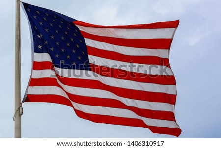 United States flag blows in the wind against a sky