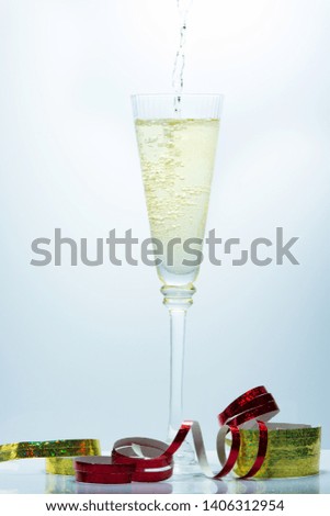 Pouring of Champagne on a fancy glass against a blue background