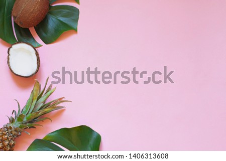 Tropical leaves and exotic fruits summer concept frame on the pink background. Top view. Copy space
