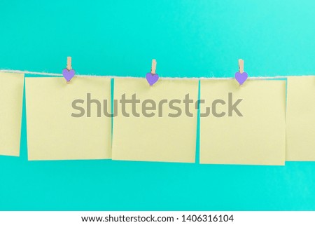 Green stickers on clothesline with clothespins isolated on blue background. Place for your text.