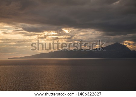 sea storm at sunset with behind the island