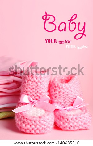 Pile of baby clothes on pink background