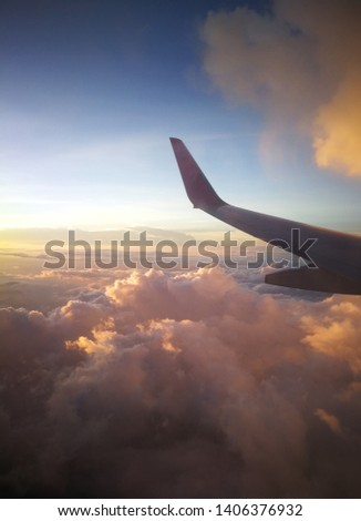 Soft clouds on the blue sky.vertical blue sky in summer.Free space for text input.The airplane window. Beautiful sky picture taken from the plane. Airplane flying over the city with a spectacular sun.