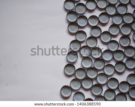 Large pile of beer bottle caps on white background