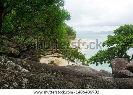 The picture shows the nudey beach on fitzroy island in Australia with stones and plants.