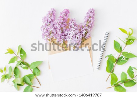 Mockup white greeting card and envelope with branches of lilac on a white background